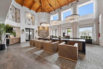 a large living room with large windows and a large table and chairs